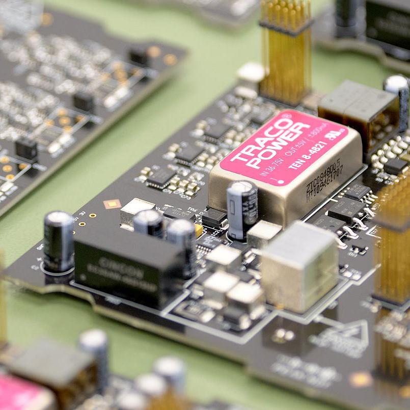 Close-up of printed circuit board with power module and capacitors, shallow depth of field