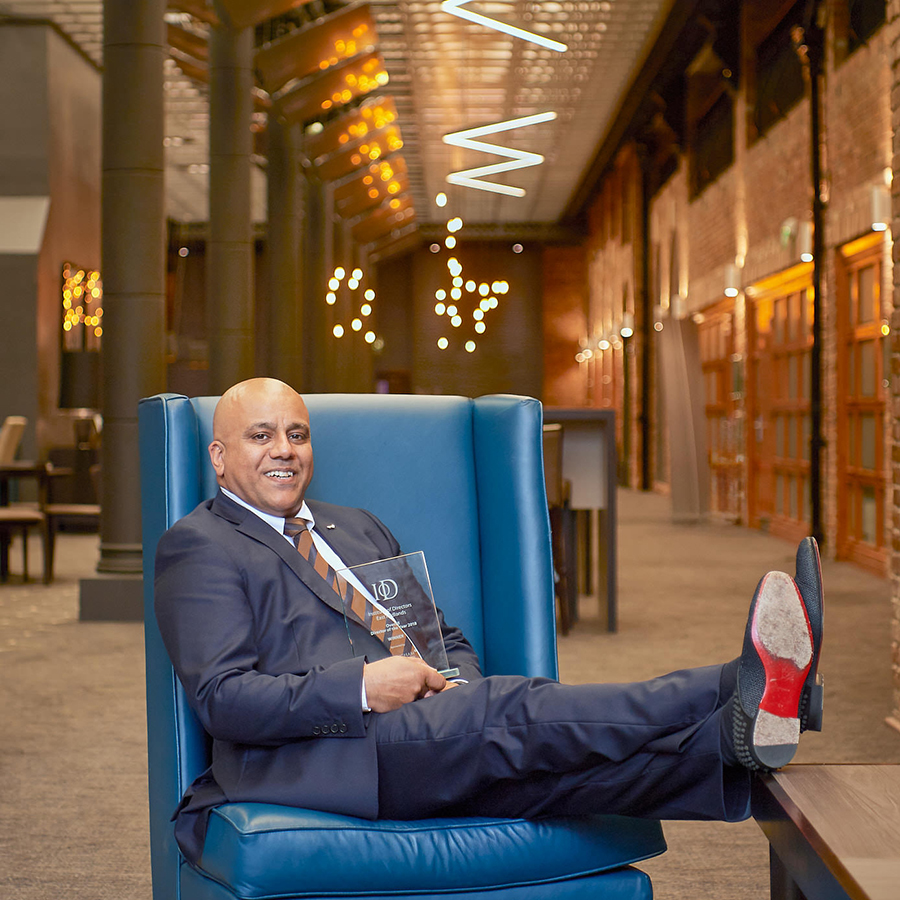 Corporate team image, leader with award seated in modern venue