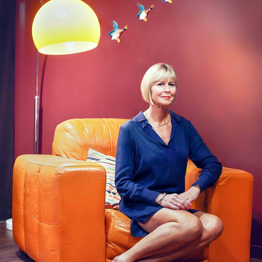 Corporate team image, leadership portrait in lounge with orange chair